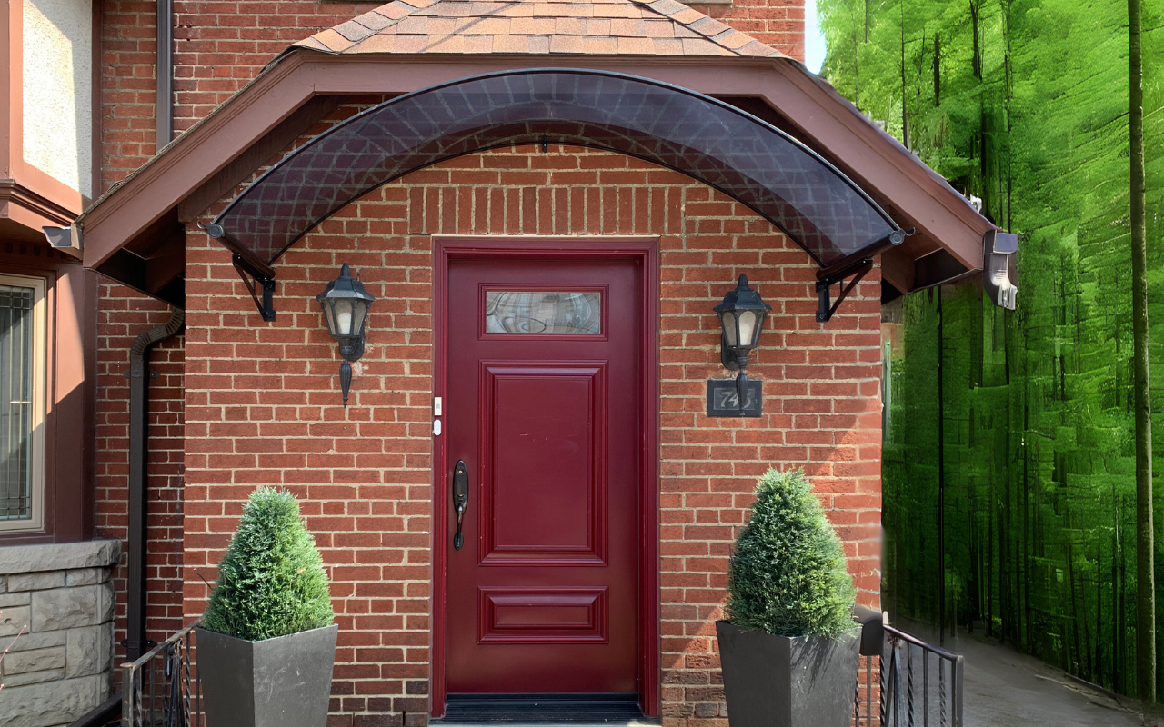 How to Choose the Right Entryway Awning 7 Tinted polycarbonate entryway awning over an elegant front door, offering year-round rain and snow protection with a stylish architectural touch