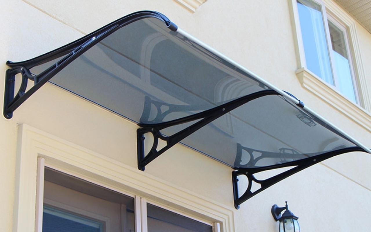 Installing Awnings on Stucco Homes: What You Need to Know 10 Polycarbonate awning installed above a stucco exterior door on a Canadian home, offering sleek weather protection and enhanced curb appeal.