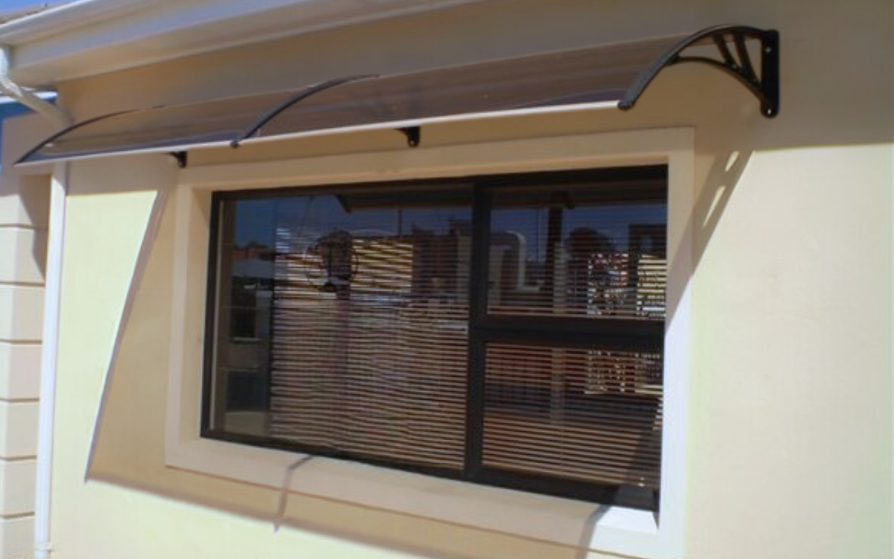 Commercial Awnings: A Smart Upgrade for Your Business Space 4 Polycarbonate commercial awning installed above a ground-floor office window